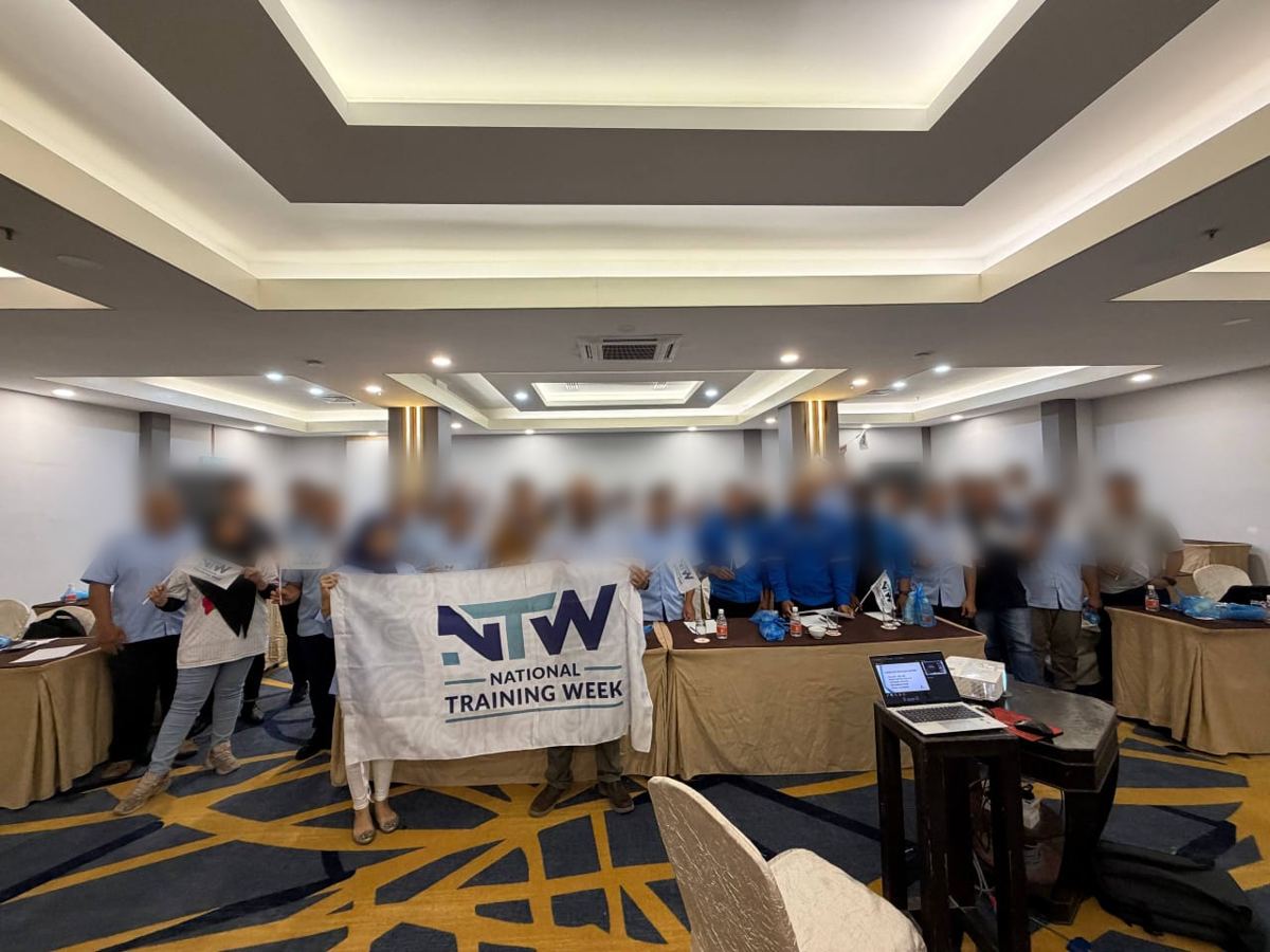 Training participants in a group photo after a session in a hotel hall